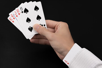 Person holding deck of cards with an ace up the sleeve