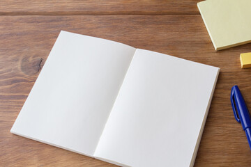 White notebook and stationery on brown desk - obrazy, fototapety, plakaty