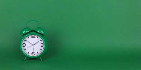green alarm clock on a green background
