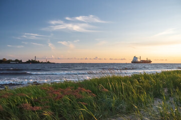 Ship leaving the harbor on sunny and clear sunny evening
