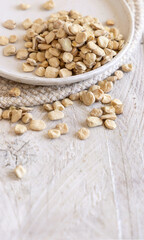 Plate of raw dry Grass pea close up on wooden table. Legumes known in Italy as Cicerchia