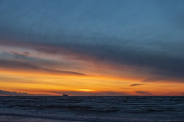 Colorful orange sunset over Baltic sea on clear summer day
