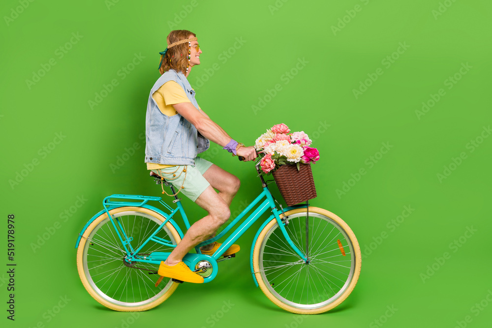 Poster Full size profile photo of handsome hippy guy driving bike look empty space isolated on green color background