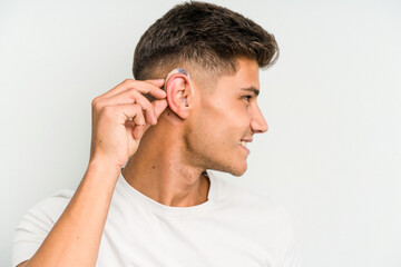 Young caucasian man wearing a hearing aid isolated on white background