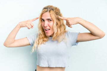 Young caucasian woman isolated on blue background showing a disappointment gesture with forefinger.