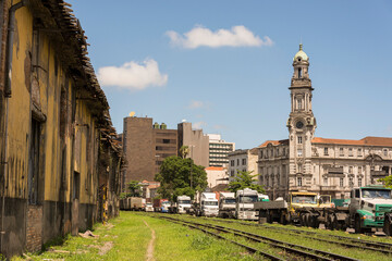 Fototapeta na wymiar Santos, Brazil. Coffee Stock Exchange building from port avenue with several trucks parked along the railroad. 