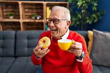 Senior man smiling confident having breakfast at home