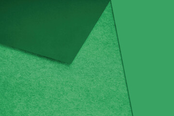 Plain and Textured green papers randomly laying to form M like pattern and triaangle for creative cover design idea