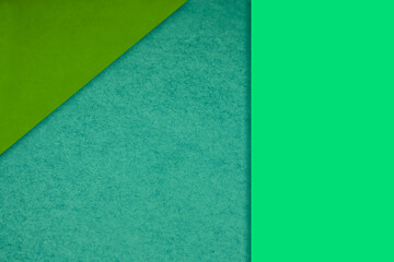 Fototapeta na wymiar Textured and plain neon green blue sheet papers forming two triangles and vertical blank rectangle for creative cover designing