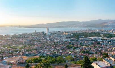 Obraz premium Landscape of city at sunset with sea in the background.