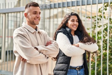 Man and woman couple standing together with arms crossed gesture at street