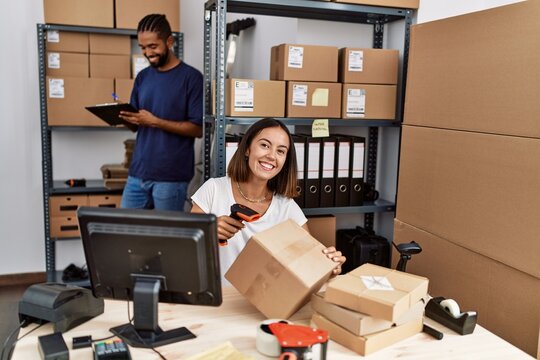 Man and woman business partners scanning package using barcode reader at storehouse
