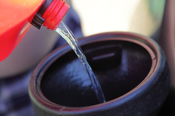 Gasoline transfusion from a plastic gas tank through a plastic funnel. Danger of ignition of fuel...
