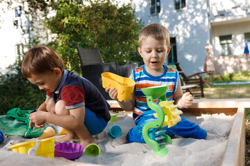 two little boys playing in the sandbox