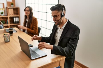 Two hispanic call center agents working at the office.