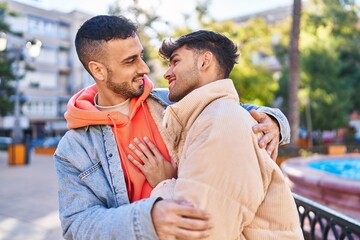 Fototapeta premium Two man couple hugging each other standing at park