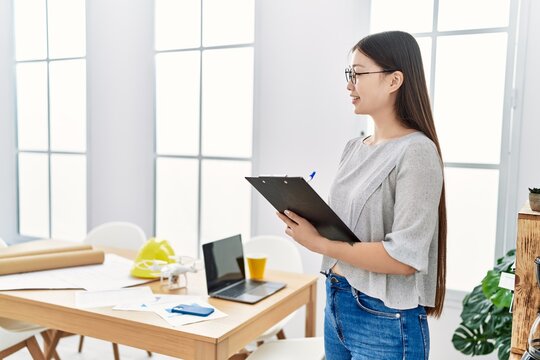 Young asian woman holding clipboard at the office