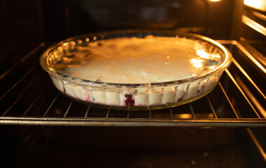 cooking pie in the oven, homemade pastries, cherry pie in a glass plate. The rise in price of sugar, confectionery. sugar shortage, collapse of candy stores