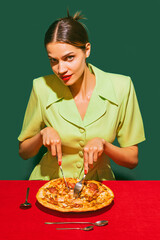Young woman eating delicious Italian pizza isolated over green background. Traditional meal