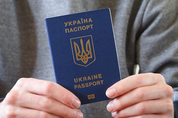 Ukrainian biometric passport in the hand of its owner in close-up.