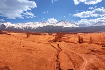 Naklejka premium Beautiful landscape road in autumn forest with snow peaks mountains Chuysky tract, Altai Kurai steppe Russia. Aerial top view