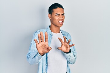 Young african american guy wearing casual clothes disgusted expression, displeased and fearful...