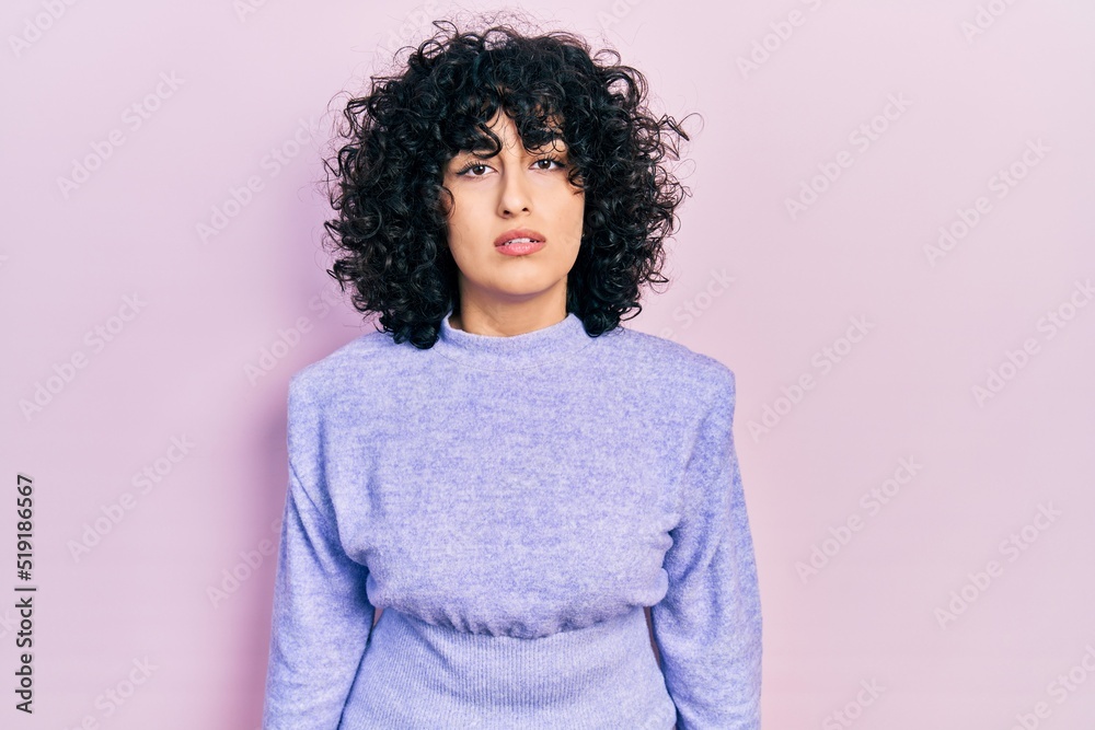 Poster Young middle east woman wearing casual clothes relaxed with serious expression on face. simple and natural looking at the camera.