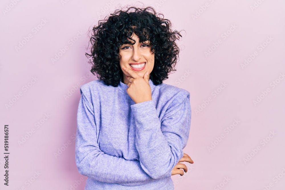 Sticker Young middle east woman wearing casual clothes looking confident at the camera smiling with crossed arms and hand raised on chin. thinking positive.