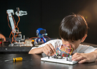 Teenage students build learning with robotic vehicles at desks in STEM engineering science education classes.