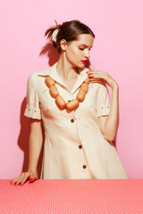 Portrait of young woman having necklace made from sausages. Creative food advertisement