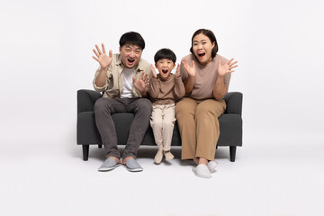 Asian family with little son sitting on sofa and excited screaming isolated over white background, Wow and surprised concept - Powered by Adobe