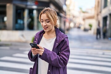 Young woman smiling confident using smartphone at street