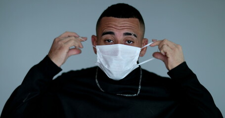 Hispanic latino young man adjusting face mask