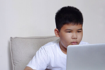 Close up face cute boy having fun watching laptop. Education, learning and technology concept.