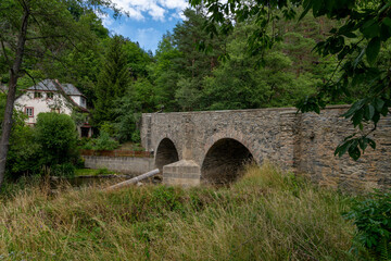 Fototapeta na wymiar The stone bridge built over the Střela River is a technical monument - Czech smallest historical city Rabstejn nad Strelou