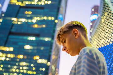 Teenager against the backdrop of the lights of the skyscrapers of the city of Moscow.