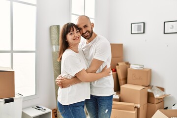 Fototapeta na wymiar Young hispanic couple smiling happy and hugging moving at new home.