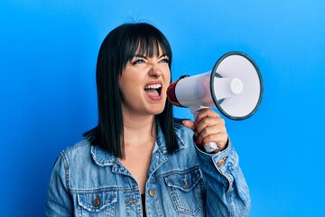 Young plus size woman shouting using megaphone
