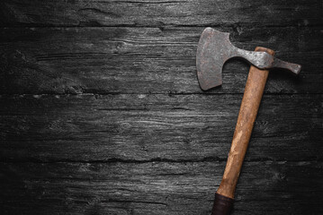 Old viking axe on the wooden flat lay table background with copy space.