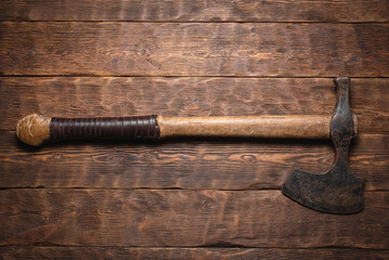 Old viking axe on the wooden flat lay table background with copy space.