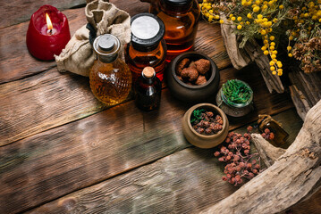 Herbal medicine concept background. Dry natural ingredients and remedy bottle on the wooden table background with copy space. Top view.