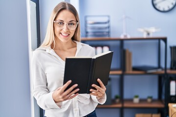 Young woman business worker reading book at office