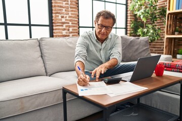 Middle age man working using laptop at home