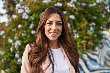 Fototapeta premium Young hispanic woman smiling confident walking at park