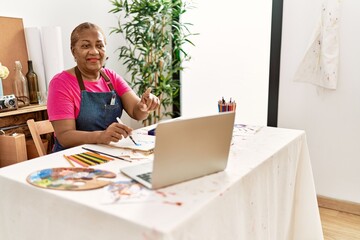 Fototapeta na wymiar Senior african american woman having online draw class at art studio