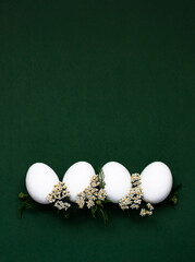 Festive Easter eggs with white small flowers on a green background. - 519196756