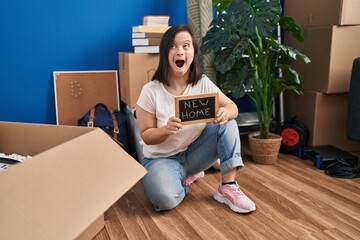Hispanic girl with down syndrome sitting on the floor at new home angry and mad screaming...