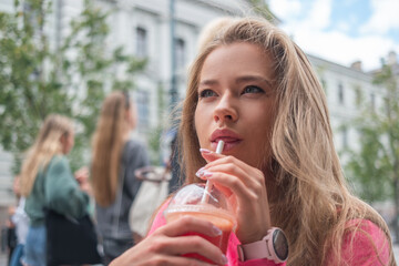 Woman using a straw to drink grapefruit juice