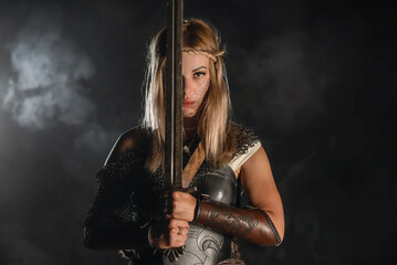 Warrior woman in the armor and with the sword concept.