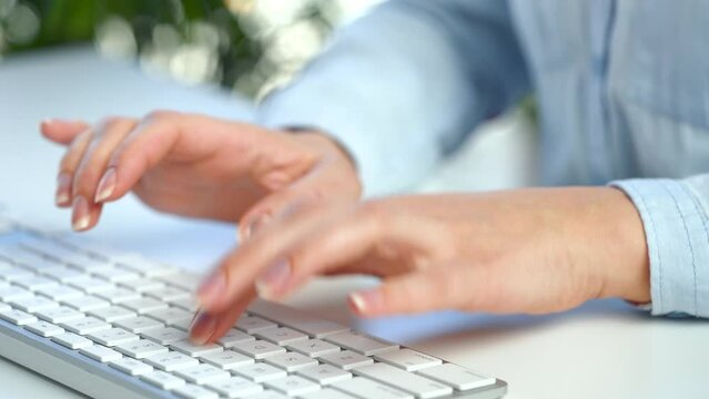 Female hands busy working on computer keyboard for sending emails and surf on a web browser